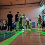 bawiący się uczniowie na sali gimnastycznej, kolorowe światła