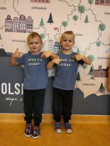 Na zdjęciu 2 chłopców pokazujący palcem wskazującym na własne takie same koszulki z napisem ,,It's friday".