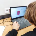 uczeń tworzący projekt na laptopie