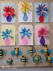 Prace plastyczne. Kolorowe kwiaty w wazonie. Żółte pszczoły z rolki po papierze z niebieskimi skrzydłami.