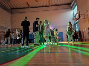 bawiący się uczniowie na sali gimnastycznej, kolorowe światła